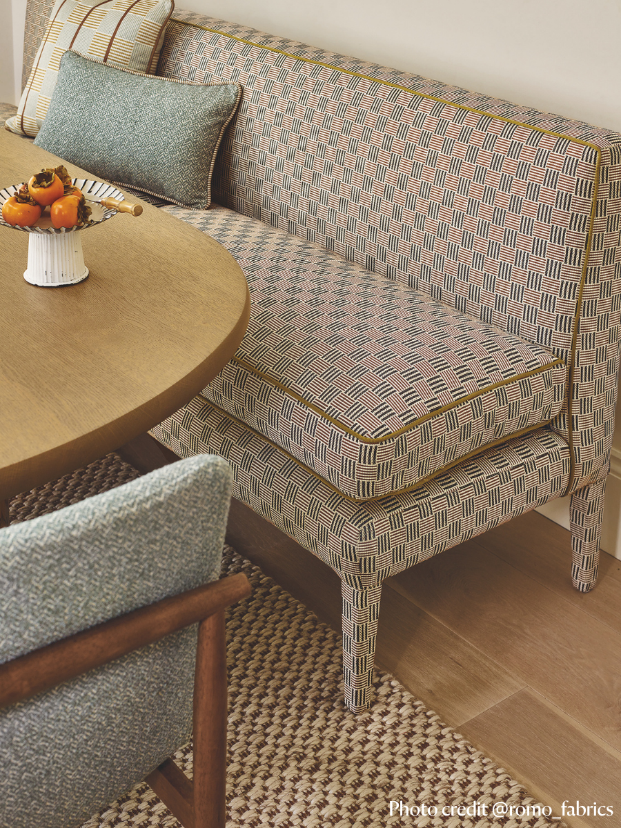 dining banquette, in a check fabric with contrast piping. Set up in a dining room setting