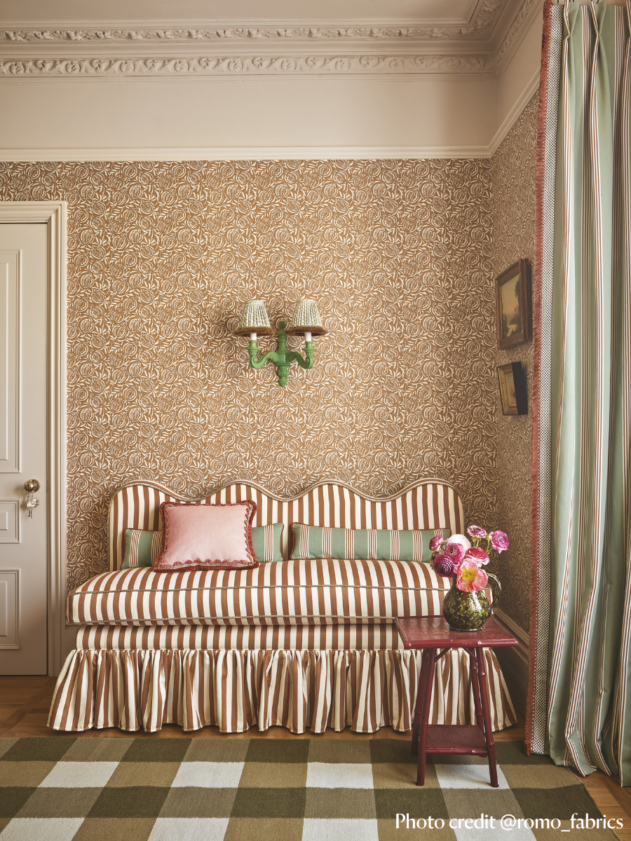 Banquette with wavy top, striped fabric and a ruffled skirt around the based. fixed back seating in hallway setting
