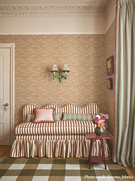 Banquette with wavy top, striped fabric and a ruffled skirt around the based. fixed back seating in hallway setting