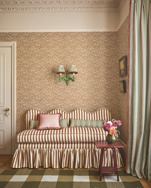 Banquette with wavy top, striped fabric and a ruffled skirt around the based. fixed back seating in hallway setting