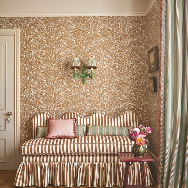 Banquette with wavy top, striped fabric and a ruffled skirt around the based. fixed back seating in hallway setting