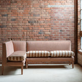 Striped sofa against a brick wall in a room with large windows.