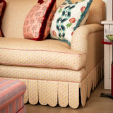 Front view of the Symington rolled-arm sofa featuring a yellow floral pattern and hand-tailored scalloped valance in a sitting room setting.