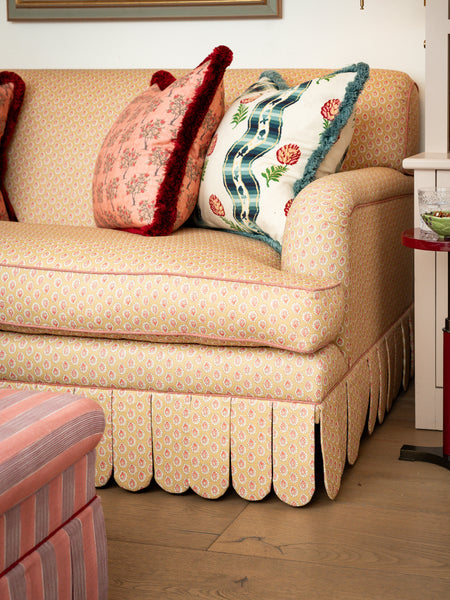 Front view of the Symington rolled-arm sofa featuring a yellow floral pattern and hand-tailored scalloped valance in a sitting room setting.