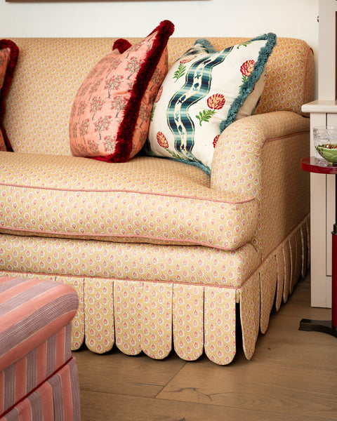 Front view of the Symington rolled-arm sofa featuring a yellow floral pattern and hand-tailored scalloped valance in a sitting room setting.