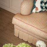 Close-up of the rolled arm cushion and hand-stitched scalloped skirt on the Symington sofa in a domestic setting.