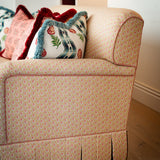 Ground-level view showing the continuous scalloped skirt detailing along the bottom edge of the Symington sofa frame.
