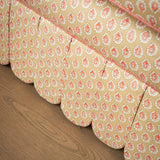 Close-up detail of the hand-piped scalloped skirt and yellow patterned upholstery on the Symington sofa base.
